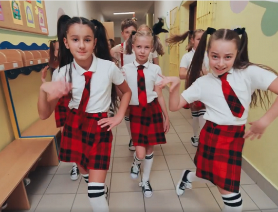 Kadr filmu SP 6 - dziewczynki tańczące na korytarzu szkolnym