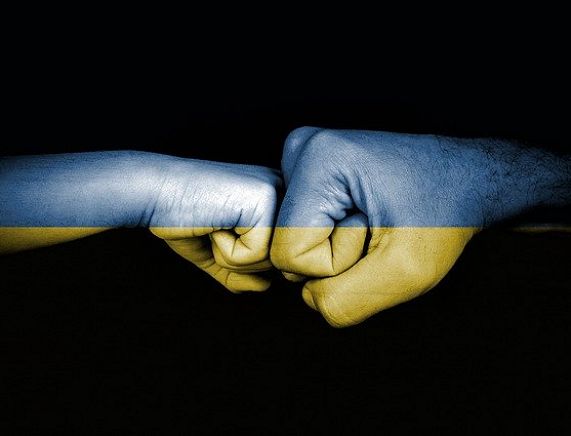 Dłonie w geście zgody na tle ukraińskiej flagi - źródło fot. pixabay
