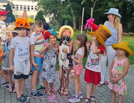 dzieci w kolorowych kapeluszach pozują do zdjęcia z pieskiem