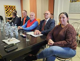 Osoby z organizacji pozarządowych rozmawiają przy stole na spotkaniu konsultacyjnym.